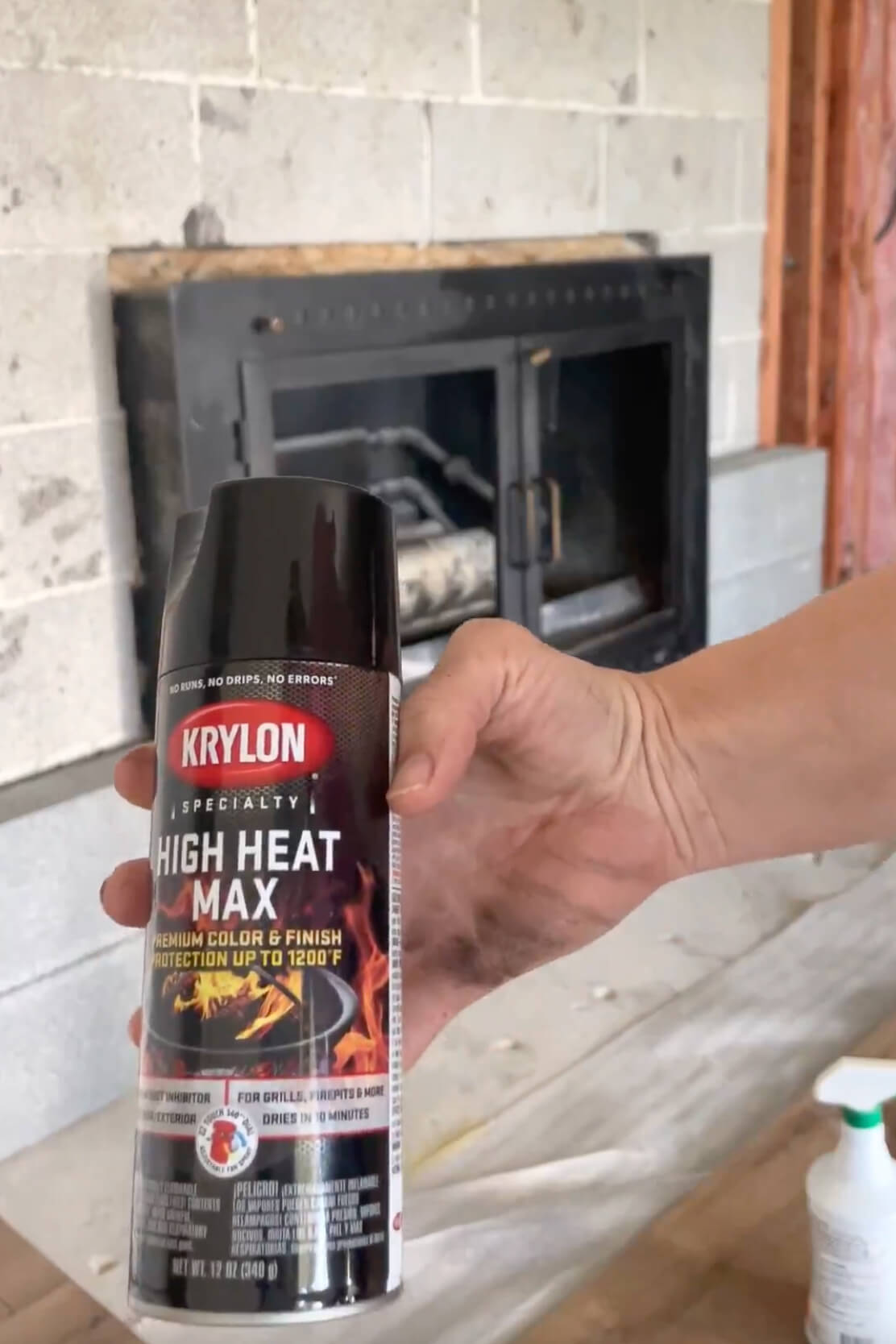 Using high heat spray paint for refreshing a fireplace.